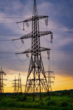 Akşam gökyüzünde elektrik kulesi. Güç iletim tesisleri.