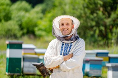 Arı yetiştiricisi arı kovanının yanında duruyor. Apiculture. Apiary.