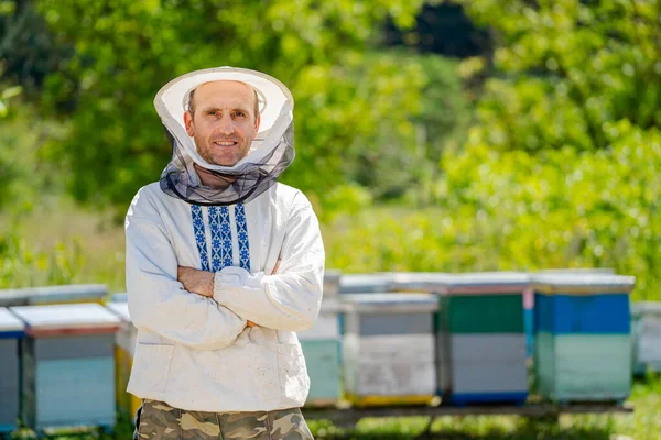 保護作業着の養蜂家 背が高いわね 春の桃園の様子 — ストック写真