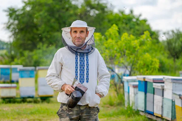 バックグラウンドでじんましんを持つ男性養蜂家の肖像画 防護服を着て — ストック写真