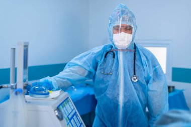 Koruyucu giysi giyen doktor. Covid-19 'un yayılmasını önlemek için işbirliği. Kendini karantinaya almak için evde kal..