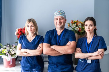 Doktor, erkek ve kadınlardan oluşan mutlu bir tıbbi ekibin ofis arka planında görüntüsü.