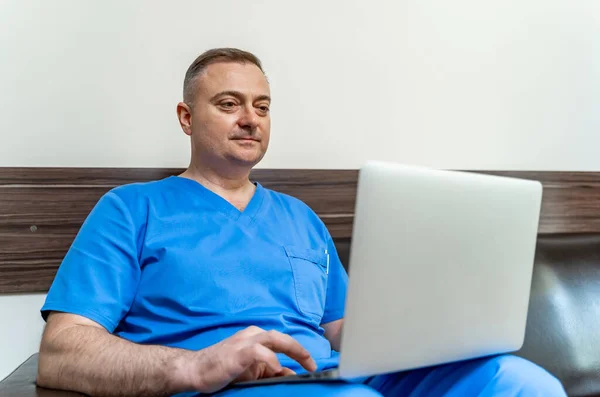 Foco Seletivo Médico Esfoliação Azul Sentado Sofá Com Laptop — Fotografia de Stock
