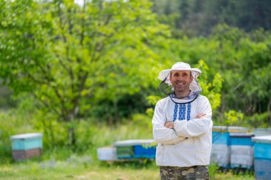 Arı yetiştiricisi arı kovanının yanında duruyor. Apiculture. Apiary.