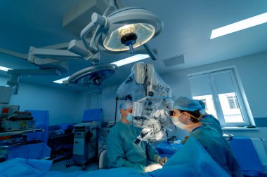 Tıbbi ekip, parlak modern cerrahi odasında cerrahi operasyon gerçekleştiriyor. Ameliyathane. Klinikte modern ekipmanlar. Acil Servis..