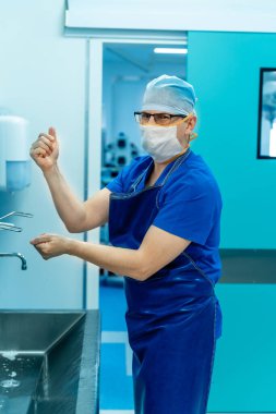 Doktor ellerini yıkıyor. Cerrah ameliyattan önce ellerini yıkıyor.