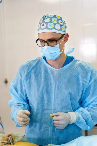 Portret van een jonge chirurg in operatiekamer. Portret van een mannelijke arts in een moderne medische ruimte. — Stockfoto