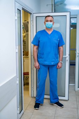 Maskeli doktor. Hastanedeki özel modern oda. Ameliyathanenin kapısı açıldı..