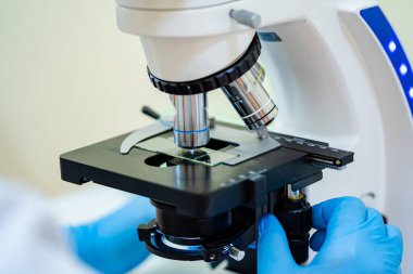 Mikroskobun yatay görüntüsü. Araştırma için hazırız. Bakteriler ve virüsler tanımlanıyor. Kapat.