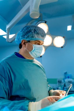 Cerrah, parlak modern cerrahi odasında cerrahi operasyon yapıyor. Ameliyathane. Klinikte modern ekipmanlar. Acil Servis..