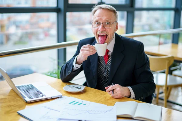 近代的なオフィスで眼鏡で笑って幸せな成熟したビジネスマン コーヒーを飲みながら会議室に座って成功したシニアビジネスマン 笑顔男でスーツでエレガントなオフィス — ストック写真
