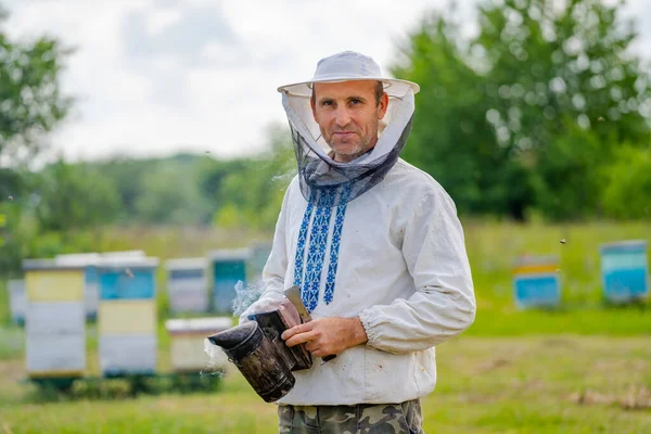 養蜂家は養蜂家の蜂や養蜂家と協力しています 手にビー スモーカー — ストック写真