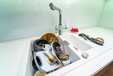 Kirli mutfak, temizlenmesi lazım. Mutfakta bulaşık yığını var..