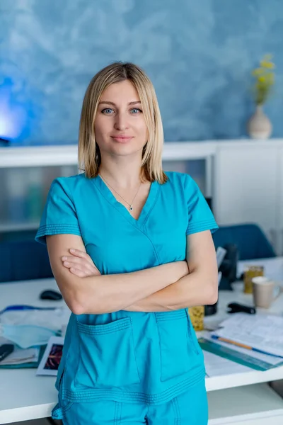 Portrait of a doctor or medical specialist. Vertical portrait. Woman in scrubs. Light background of office room. Closeup.