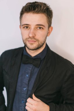 Zarif siyah takım elbiseli yakışıklı bir adam. Kameraya bakıyorum..