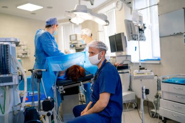 Erkek doktor ameliyathanede çalışıyor. Dairesel atış. Tıbbi ekipman. İlk yardım. Robot ekipmanları.