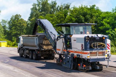 Mavi gökyüzüne karşı inşaat alanında ağır makineler. Yeni yol oluşturma.