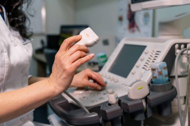 Profesyonel ekipmanlı bir doktor. Ultrason tarayıcısı doktorun elinde. Teşhisler. Sonografi