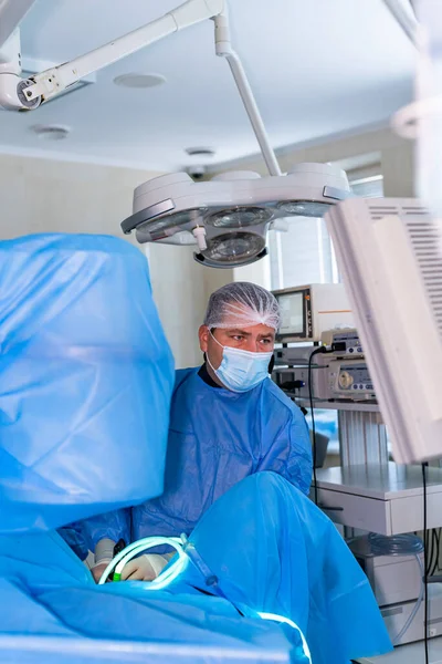 Invasive surgical system. Modern automated medical device. Surgical room in hospital with robotic technology equipment, machine arm neurosurgeon. Doctor at working place.