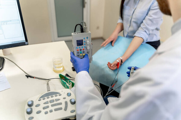 Diagnosing patient with special equipment. Putting sensors on hand. Selective focus.