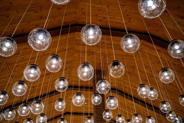 Lamps hanging on celling. Wood background. Warm light. Modern design. View from below.