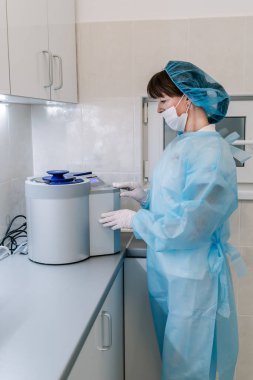 Otoklavda tıbbi aletler sterilize ediliyor. Diş hekimliği. Dişçi asistanı otoklavdan tıbbi aletleri sterilize ediyor. Seçici odaklanma. Steril diş aletleri