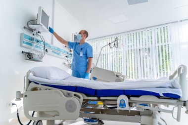 Modern tıp yatağı ve modern koğuşta özel bir cihaz. Doktor hasta için ekipman hazırlıyor..