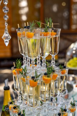 Masanın şampanyayla süslenmesi. Tatil ortamında bir kadeh şampanya. Gözlükler birbirine. Yakın çekim..