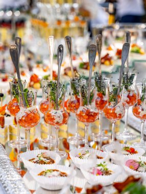 Masada atıştırmalık küçük bardaklar. Kutlamada tuzlu mezeler. Kristal gözlüklü çiğ. Yakın çekim..