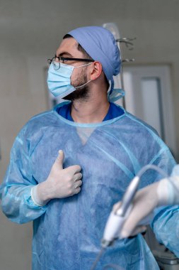 Doktor modern ekipman sağlıyor. Koruyucu giysiler giyin. Maske ve önlük. Sıhhiye Portresi.