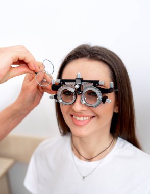 Göz bilimi diyopterleri kalibrasyon laboratuvarında. Klinikte göz gören bir kadın..