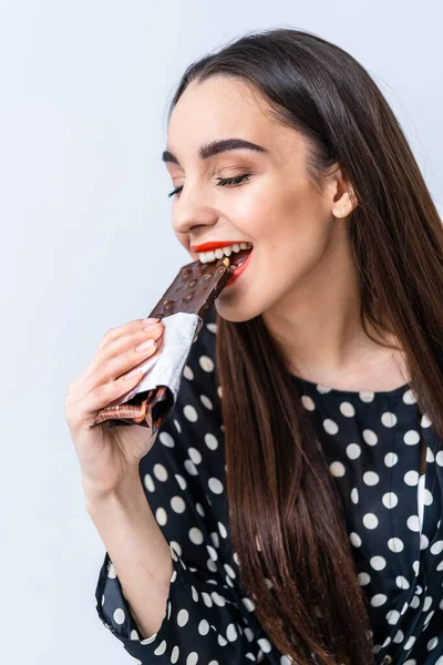 チョコレートを食べる陽気な女性 切り取られた写真 閉鎖だ ナッツ入りブラックチョコレート — ストック写真