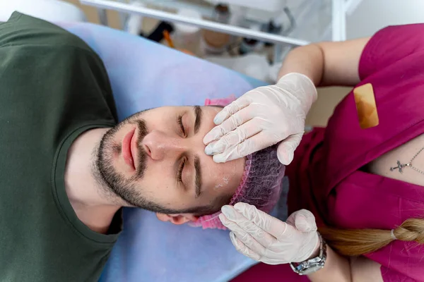 Man at cosmetologist. Relaxing, waiting time, face closeup, top view. Beauty industry concept. Guy enjoying in cosmetology.