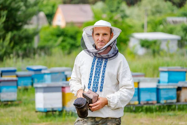 じんましんの上のオス養蜂家 防護帽だ 背景がぼやけている ミツバチと蜂蜜 — ストック写真