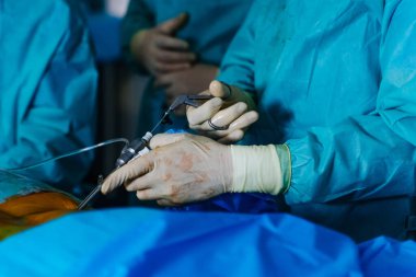 Cerrahın elindeki tıbbi aletler. Hastanede ameliyat süreci. Doktorlar ameliyat araçlarıyla ameliyat yapıyorlar.