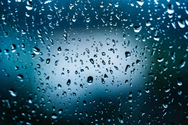 コップに水が落ちる 夏のシャワーの間に大きな雨滴が窓ガラスを打つ 雨が降る — ストック写真