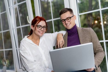 Ofiste bilgisayar üzerinde çalışan neşeli bir iş ekibi. Erkek ve kadın meslektaşlar. İş konsepti.