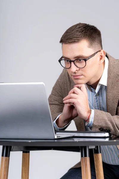 Elegant businessman looking at screen and reading task. Man using devices at home. Work at isolation.