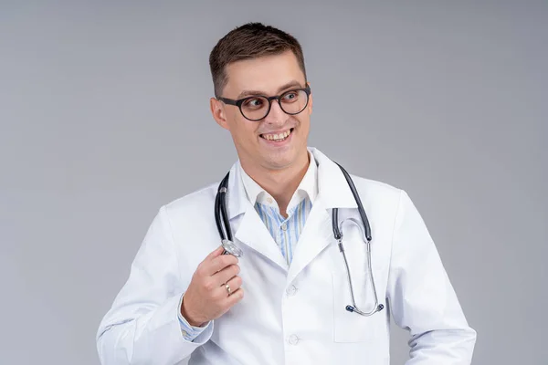 Läkarporträtt Skrubb Grå Bakgrund Leende Läkare Glasögon Med Fonendoskop Närbild — Stockfoto