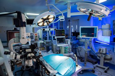 Yatağında bir hasta olan bir hastane odası ve ona bakan bir doktor. Oda aydınlık ve steril bir havası var.