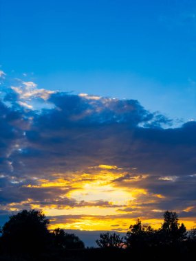 Gökyüzü birkaç bulutla mavi ve güneş batıyor.