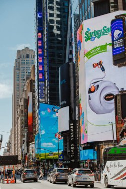New York, ABD, 28 Mayıs 2025: Parlak reklam panoları Times Meydanı. Yoğun Times Meydanı 'nda açık mavi gökyüzünün altındaki yolda canlı reklamlar ve araçlar yer alıyor..