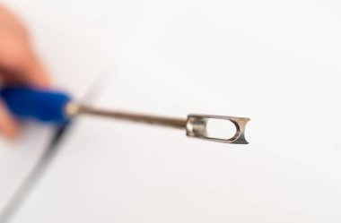 Nöroşirürji aletinin yakın çekimi. Elle tutulan bir cerrahi aletin yakın görüntüsü, sinir cerrahisinde hassas ameliyatlarda kullanılır..