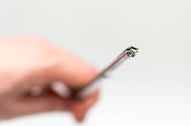 Nöroşirürji aleti hazır. Bir el, nöroşirürji için hassas bir cerrahi araç tutar ve prosedürde gerekli aletleri vurgular..