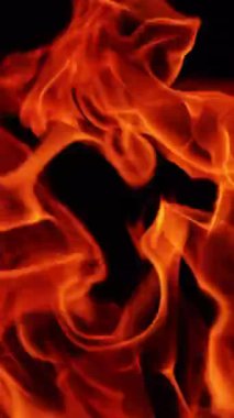 Dışarıda rüzgarda şenlik ateşinin alevleri hızla hareket ediyor. Geceleri ateş yanıyor. Kapatın. Dikey video