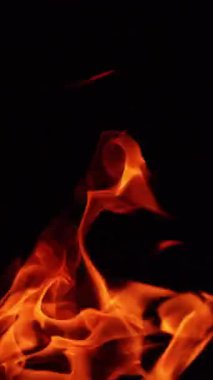 Şenlik ateşi rüzgarla soldan esiyor. Geceleri kamp ateşi yakıyorlar. Kapatın. Dikey video