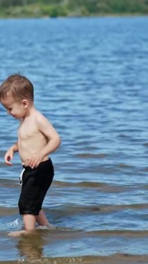 Su yaz yaşam tarzı. Yaz çocuğu nehirde eğleniyor. Dikey video