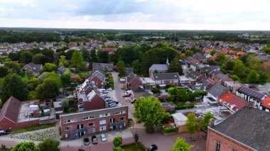 Yazın banliyö manzarası. Havadan bakıldığında, yeşil manzaralı ve yazın bakımlı evleri olan sakin bir banliyö bölgesi görülüyor..