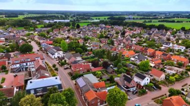 Tuhaf bir kırsal kesimin genel görünümü. Yeşil tarlaları, temiz evleri, virajlı yolları ve çiçek açan bahçeleri olan sakin bir köyün havadan görünüşü..
