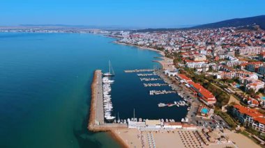 Marina sahilli sahil manzarası. Berrak mavi gökyüzünün altında canlı bir kıyı kasabası boyunca yuva yapmış, teknelerle dolu bir marinanın çarpıcı hava manzarası..